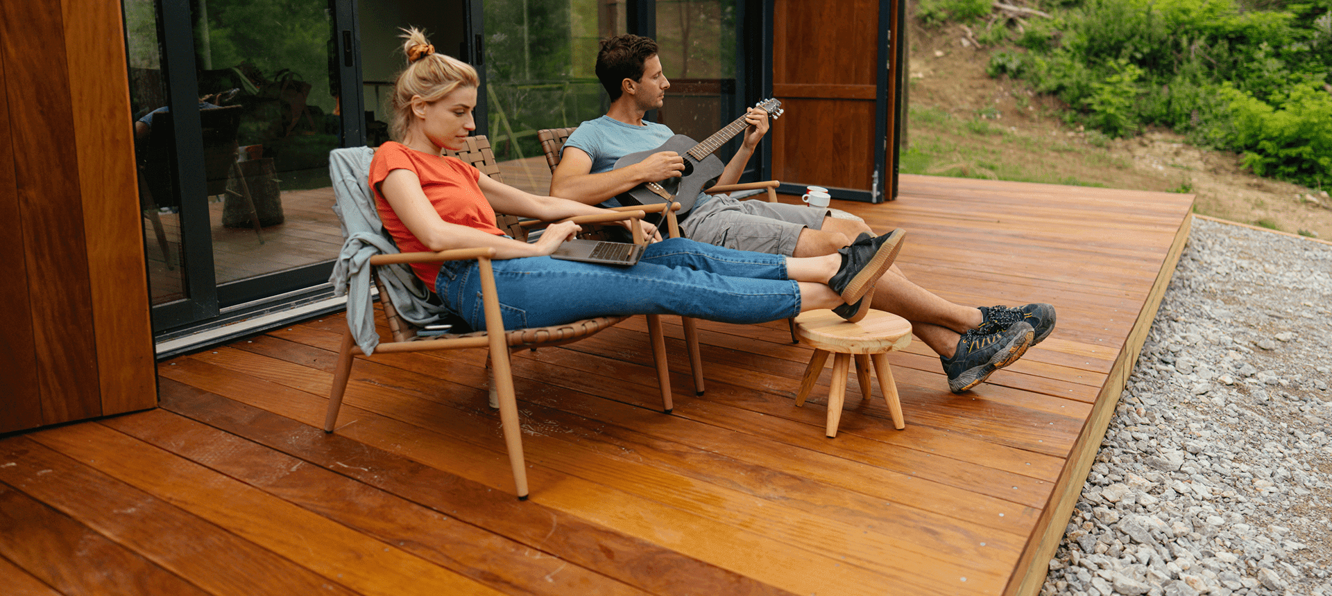 Couple relaxing on wooden deck with guitar